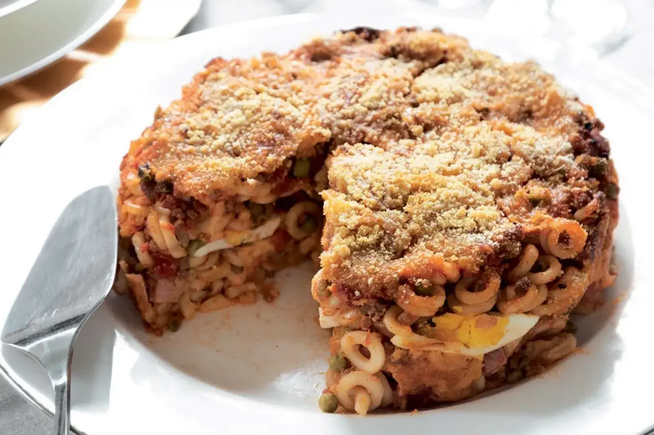 Anelletti alla siciliana, un tortino di pasta al forno con rag&ugrave;, piselli, uova sode e formaggio, croccante fuori e morbido dentro.