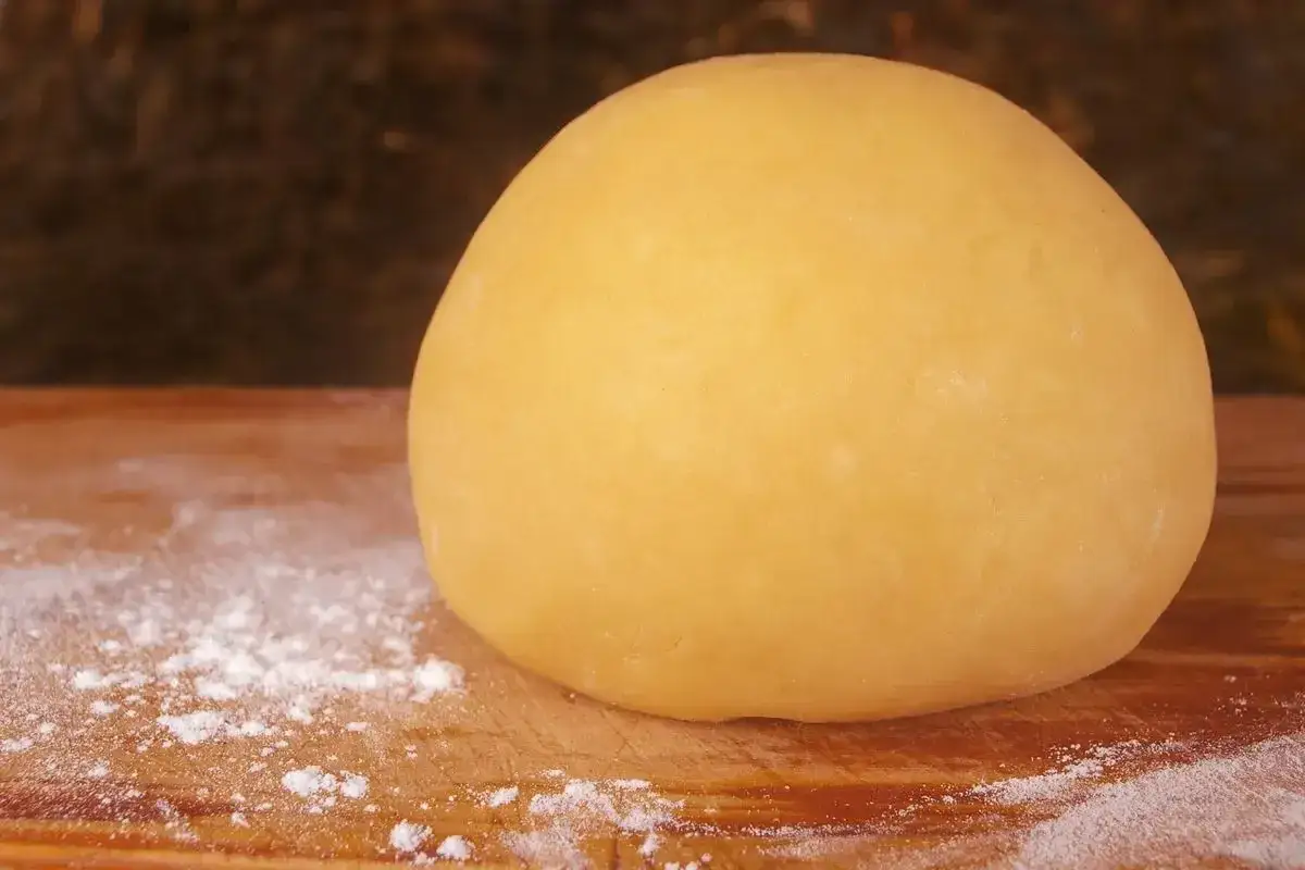 Impasto giallo dorato, pronto per essere steso. &Egrave; la pasta frolla per pastiera, che attende di diventare la base di un dolce tradizionale.