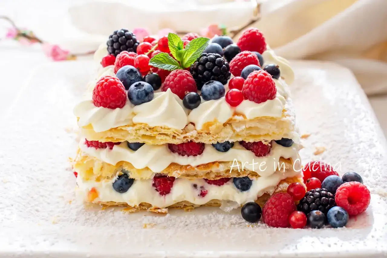Torta millefoglie con panna e frutti di bosco freschi, un capolavoro di sfoglia croccante e crema vellutata.