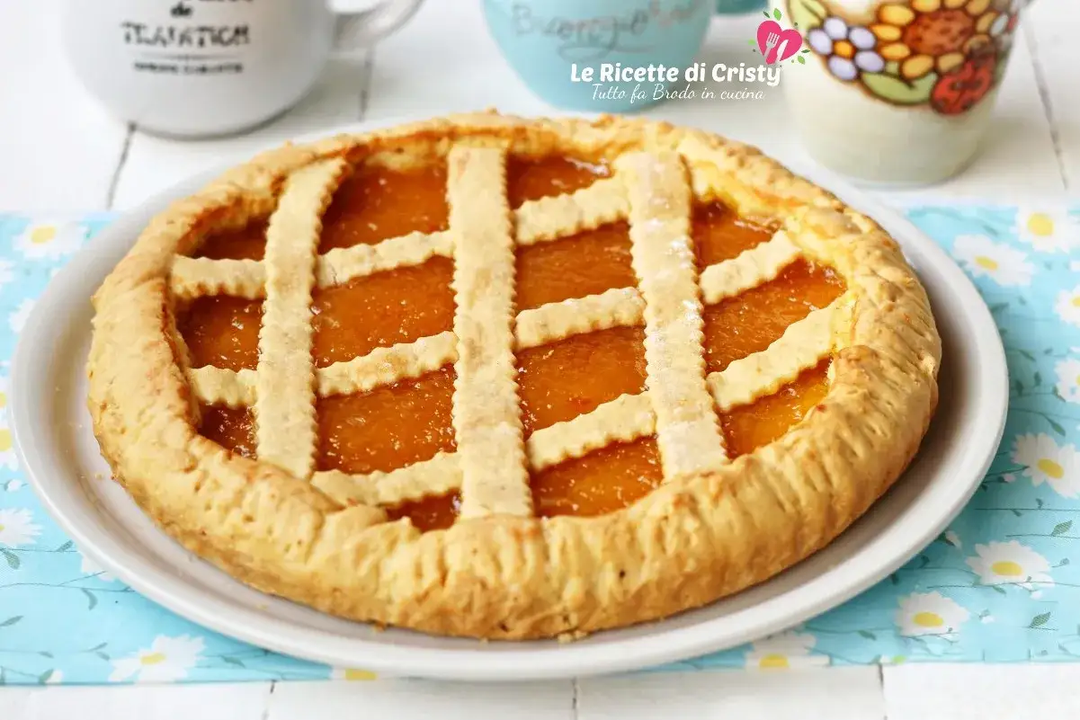 Una deliziosa crostata di marmellata, con la sua crosta dorata e il ripieno arancione brillante, pronta per essere gustata.