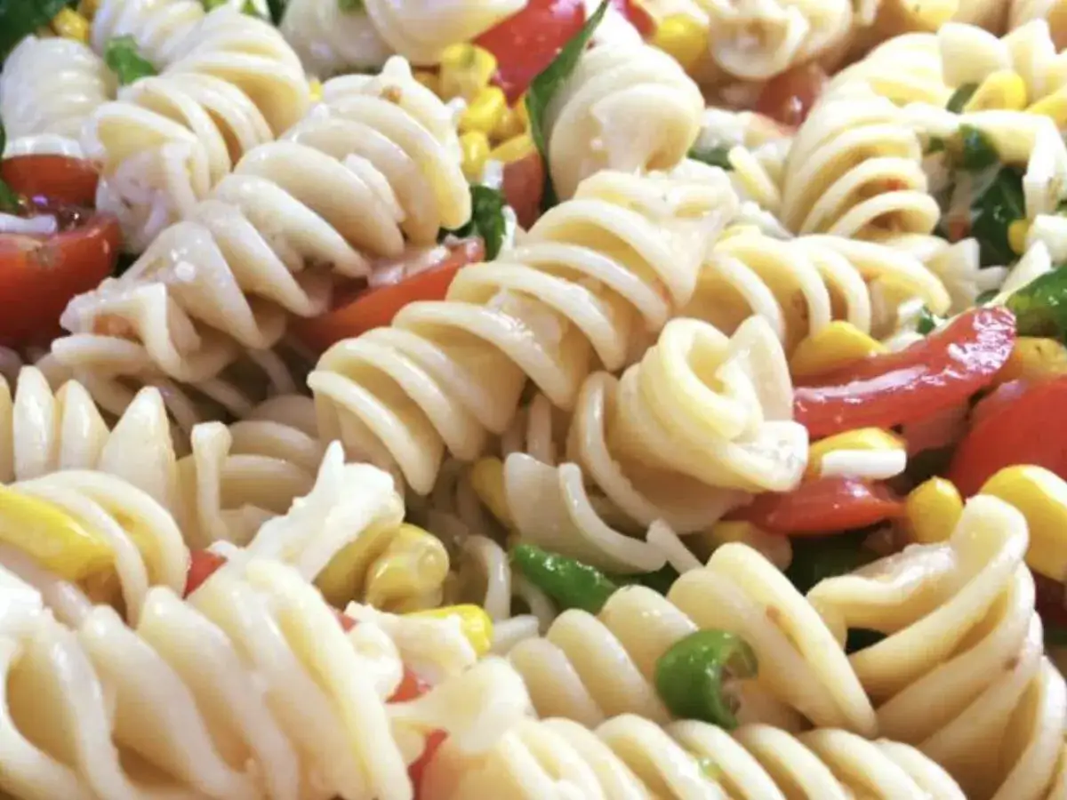 Pasta fredda saporita con fusilli, pomodorini, mais e peperoni. Un piatto estivo perfetto.