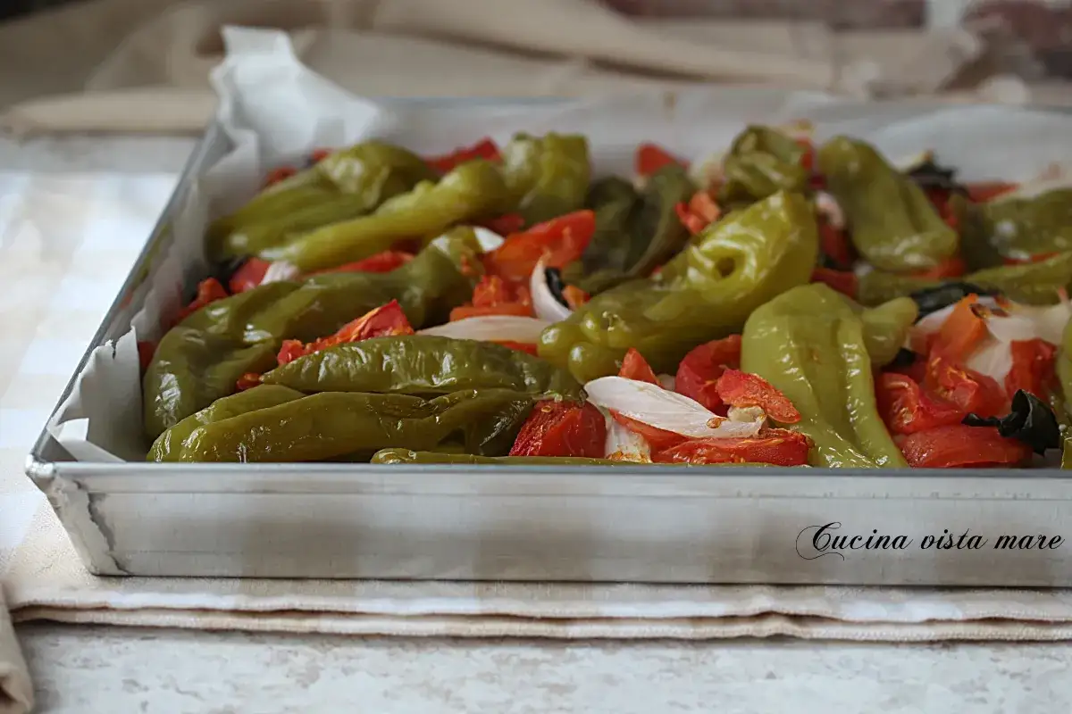 Friggitelli al forno con pomodoro e cipolla, un contorno saporito e colorato, pronto per essere gustato.