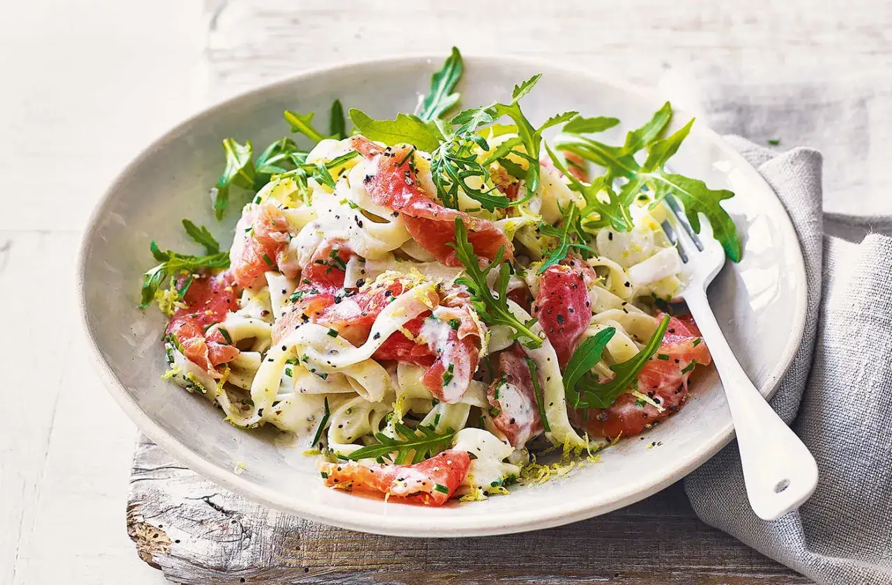 Pasta fresca con salmone affumicato, rucola e scorza di limone, un piatto leggero e gustoso.
