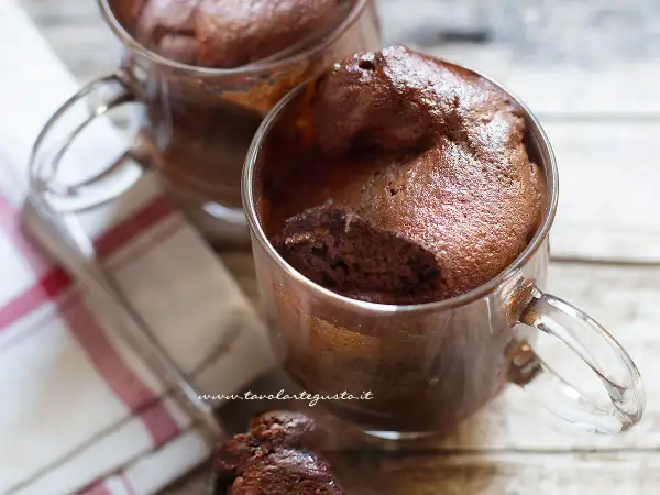 Due golose tortine in tazza al microonde, soffici e al cioccolato, pronte per essere gustate.