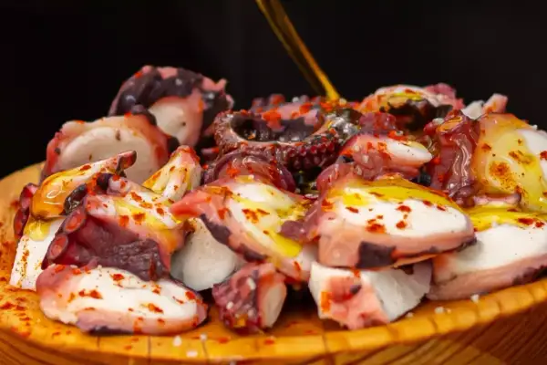 Pezzi di polpo succulento, conditi con olio e paprika, pronti per la cottura. Un piatto che celebra la bontà del mare.