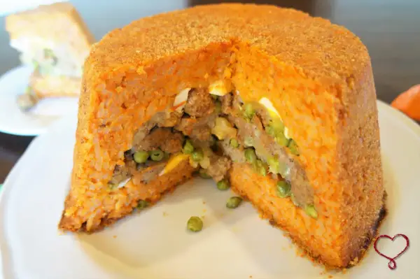 Un gustoso sartu di riso, con ripieno di carne, piselli e uova, cotto fino a doratura.