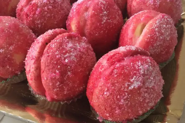 Dolci pesche ricoperte di zucchero scintillante, pronte per essere gustate.