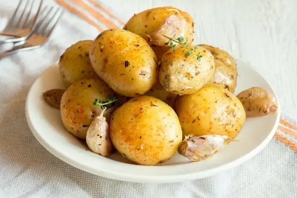 Patate lesse al microonde condite con erbe e aglio, pronte per essere gustate.