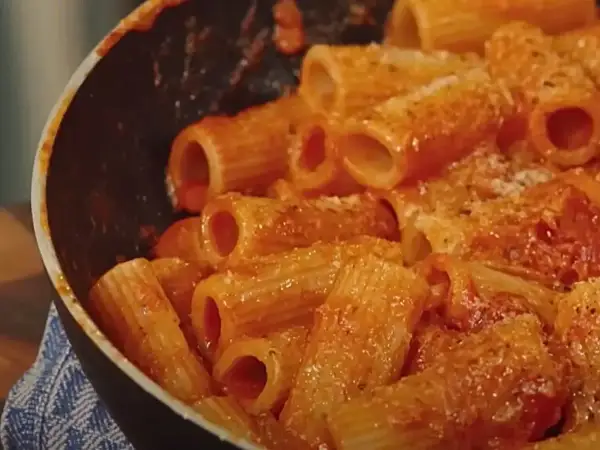 Rigatoni conditi con un sugo rosso ricco e cremoso, pronti per essere gustati in una **pasta alla zozzona** da leccarsi i baffi.