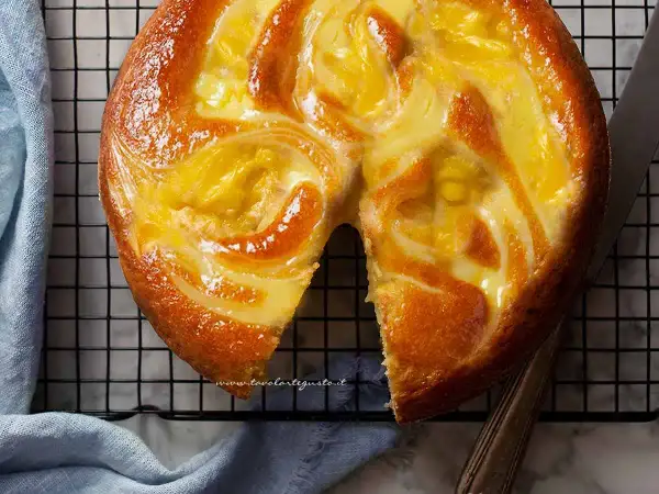 Torta soffice con un vortice di crema pasticcera dorata, appena sfornata e pronta per essere gustata.
