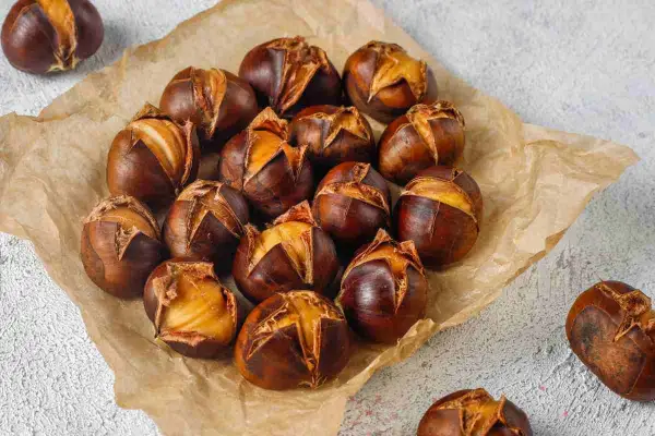 Castagne perfette cotte in friggitrice ad aria, con la buccia leggermente aperta che rivela il frutto dorato.