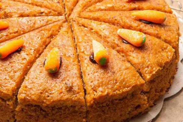 Fetta di torta carote e noci, decorata con caramelle a forma di carota.