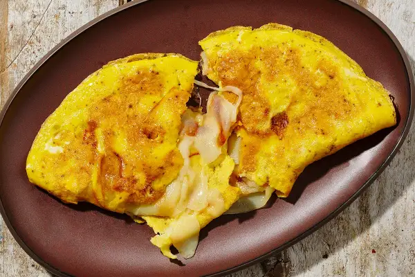 Omelette dorata e soffice, ripiena di formaggio filante. Una deliziosa omelette ricetta per una colazione o un pasto veloce.