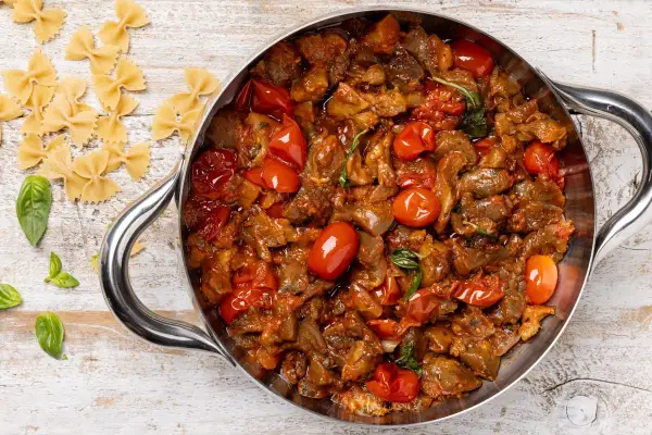 Sugo con melanzane e pomodorini in padella, pronto per condire la pasta.
